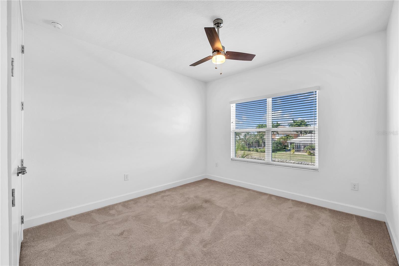 Additional bedroom with carpet and fan and built-in closet offers comfort and privacy.