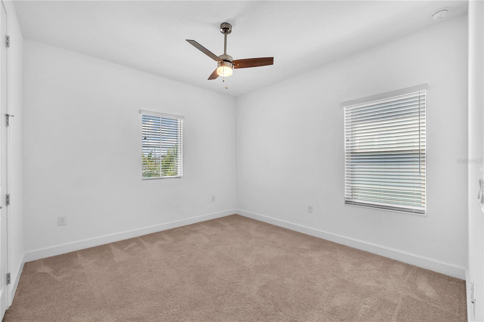 Additional bedroom with carpet and fan and built-in closet offers comfort and privacy.
