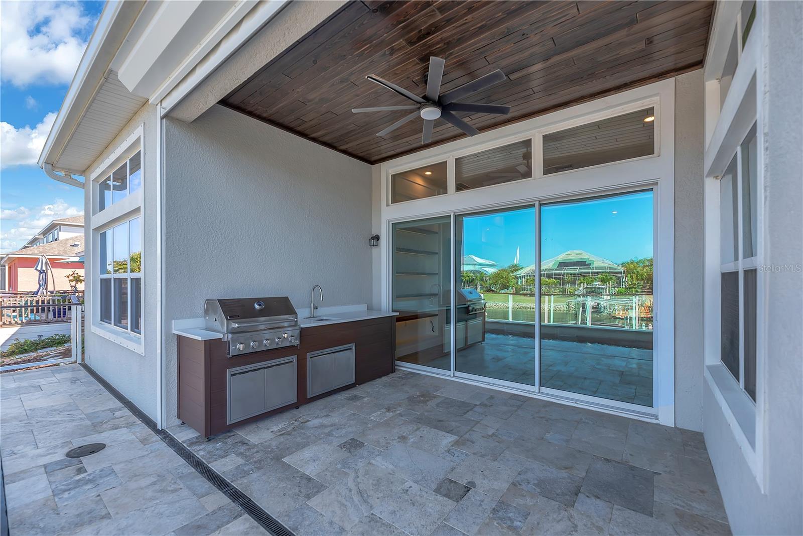The spacious lanai is designed for effortless entertaining, complete with an outdoor kitchen and sink — perfect for grilling fresh catch and serving drinks poolside.