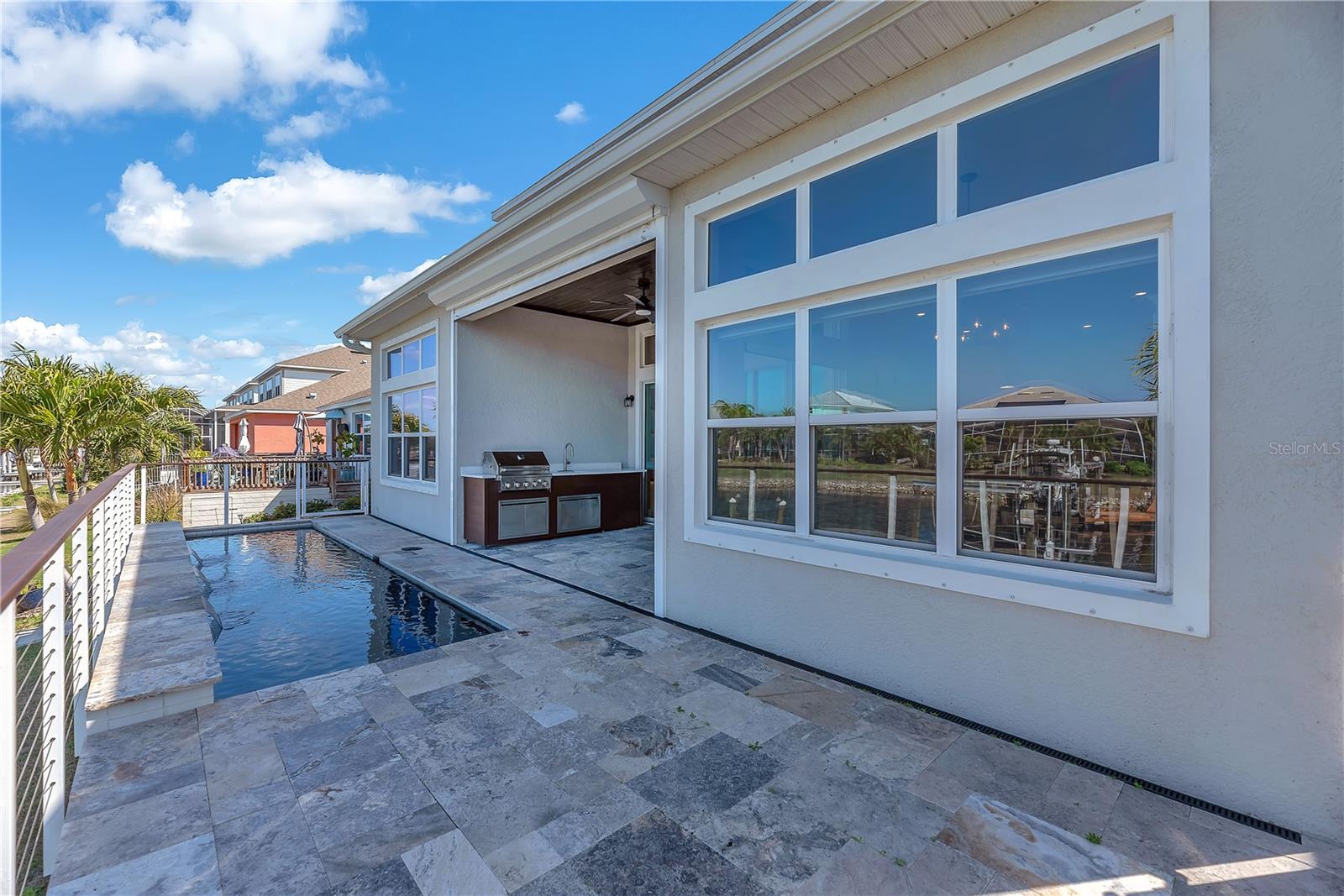 A newly installed, hurricane-rated remote-controlled Storm Screen adds both protection and comfort, allowing you to open the living room’s accordion glass doors wide and enjoy seamless indoor-outdoor living while keeping insects at bay.