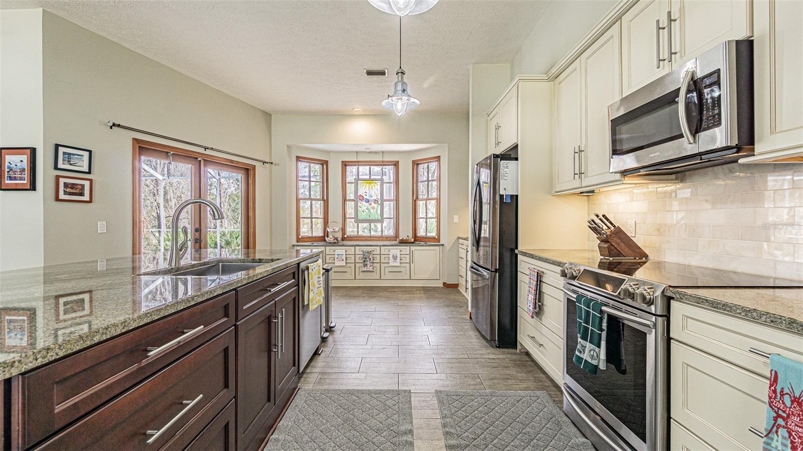 Same Granite in Kitchen and Baths with Tile Accest in Primary Shower