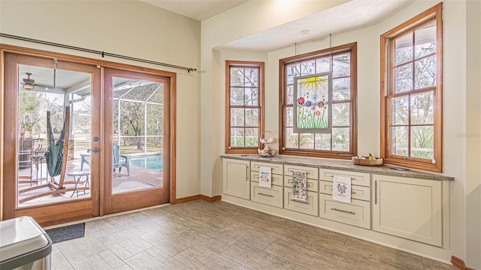 Breakfast Nook Area with Built in Cabinets French Doors to Pool Lanai