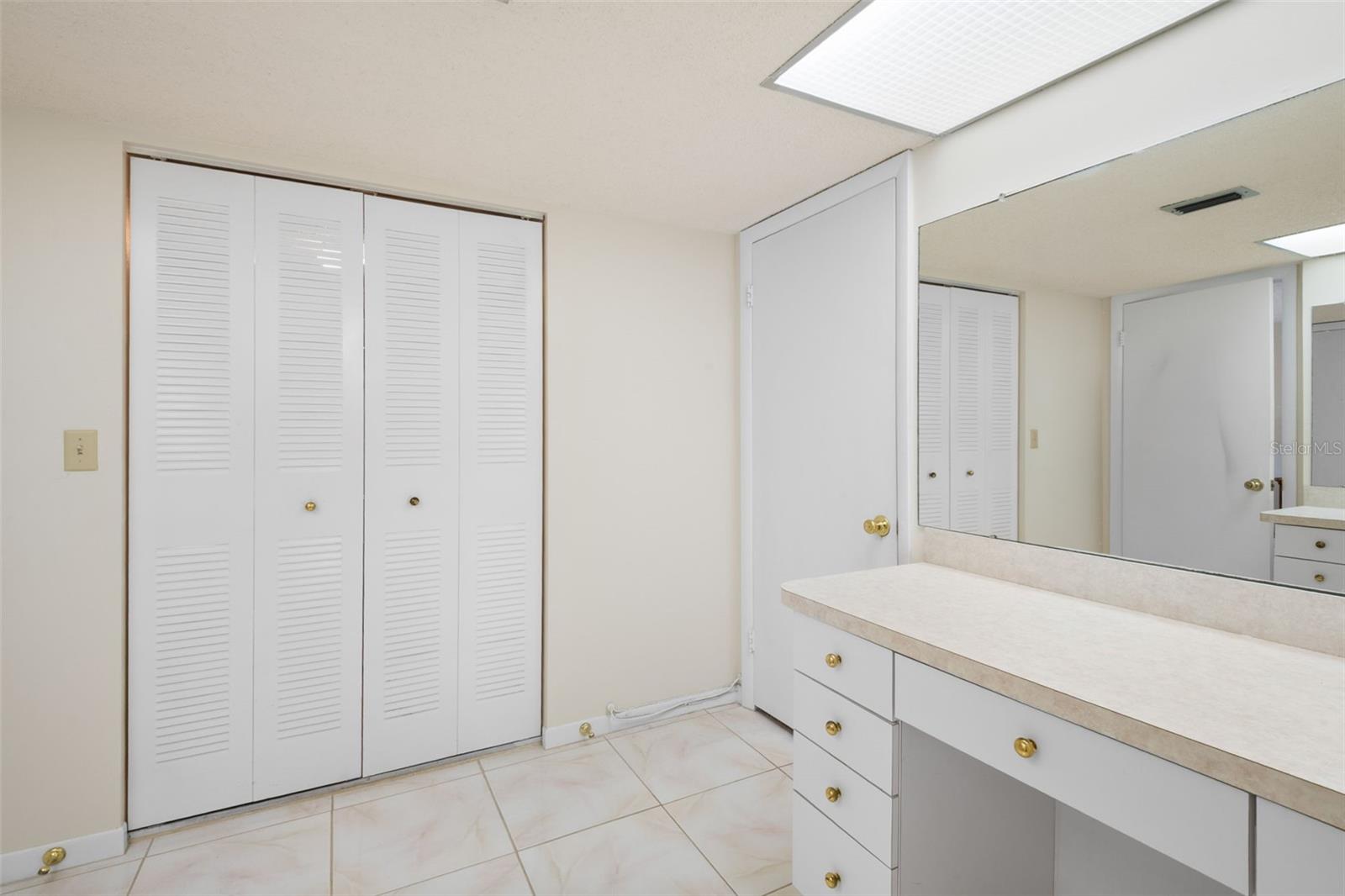 Spacious ensuite primary bath, with two vanities and a walk-in closet