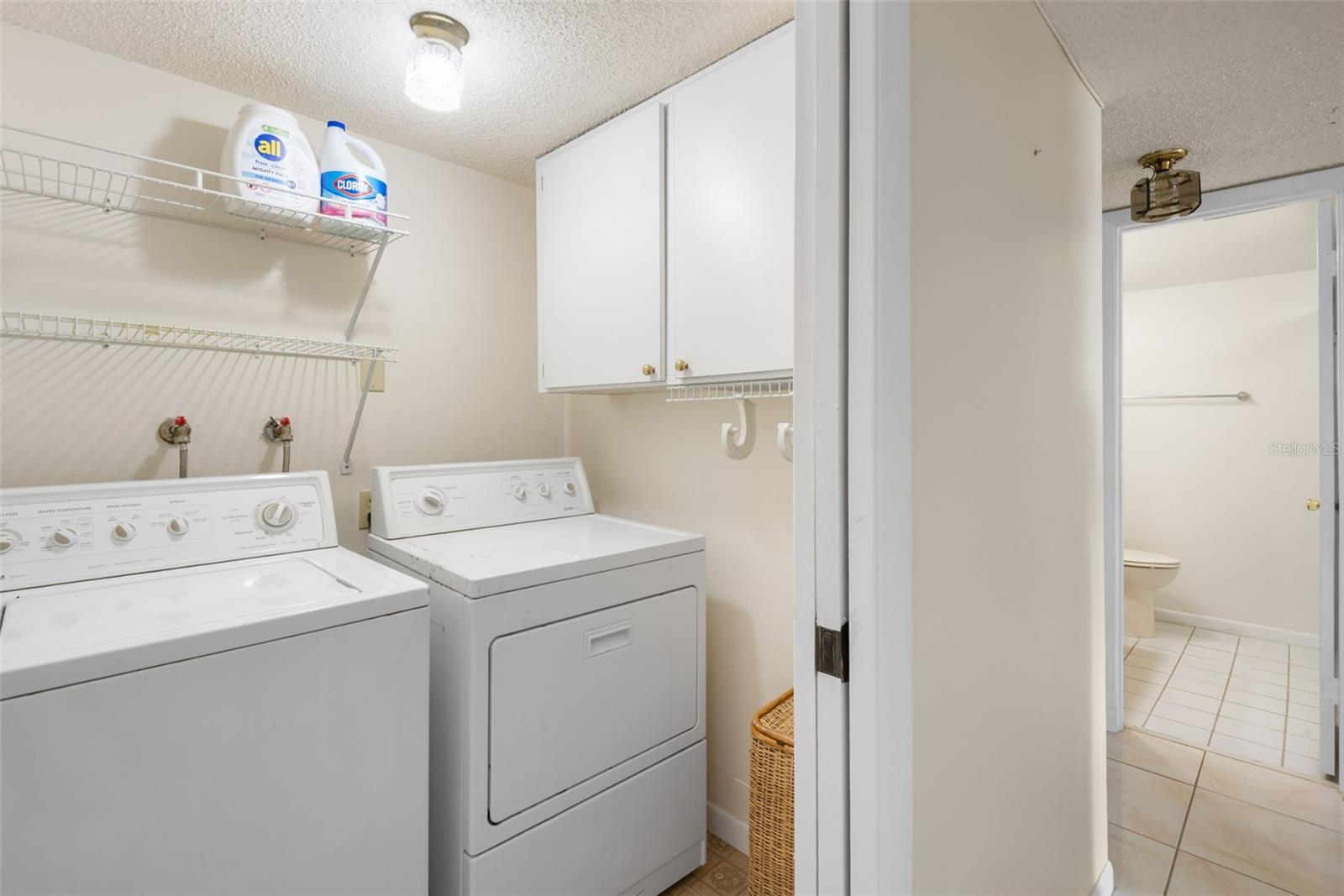 Laundry room with cabinet storage and shelving