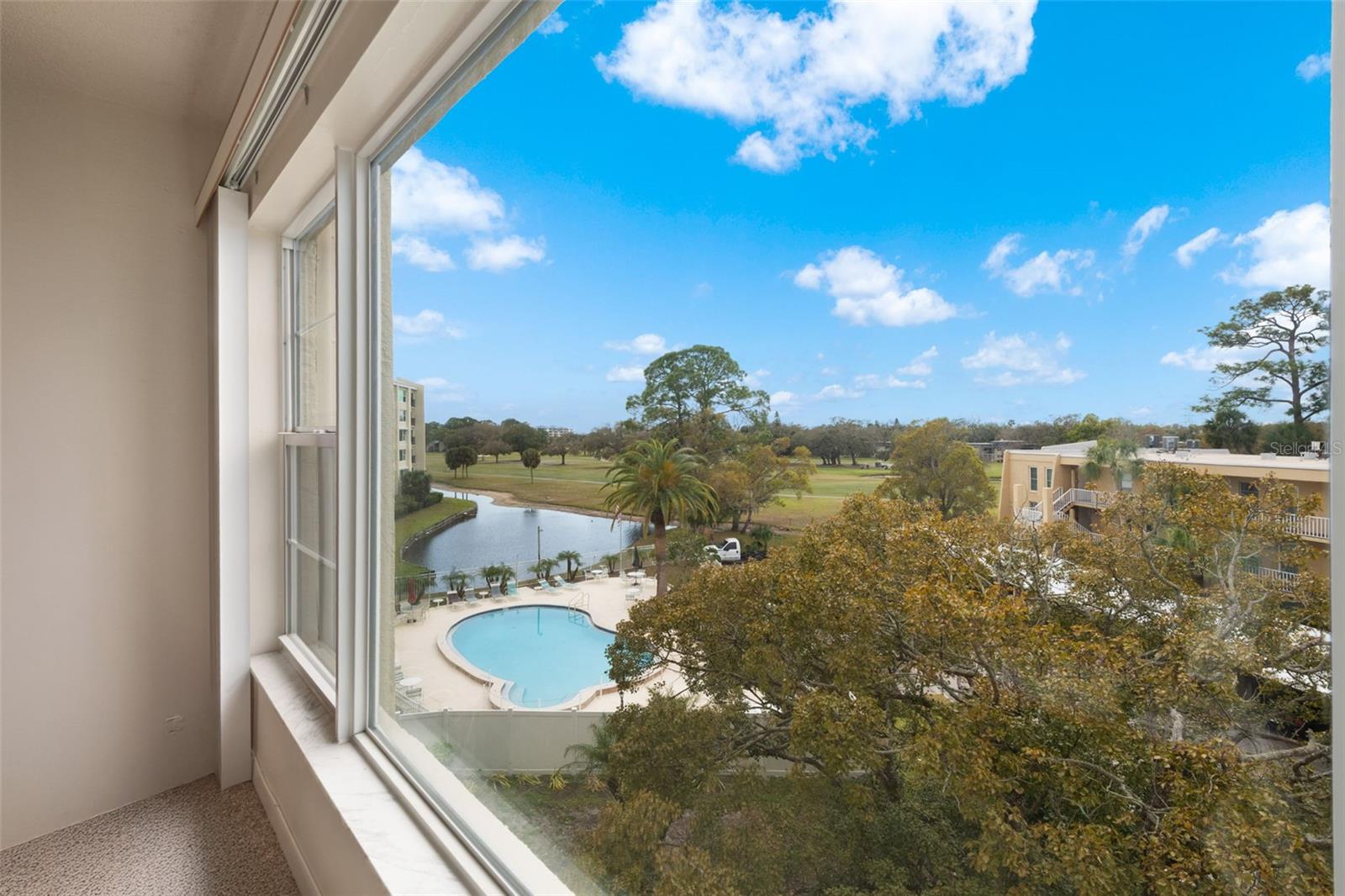 View of pool and golf course from the large living room window