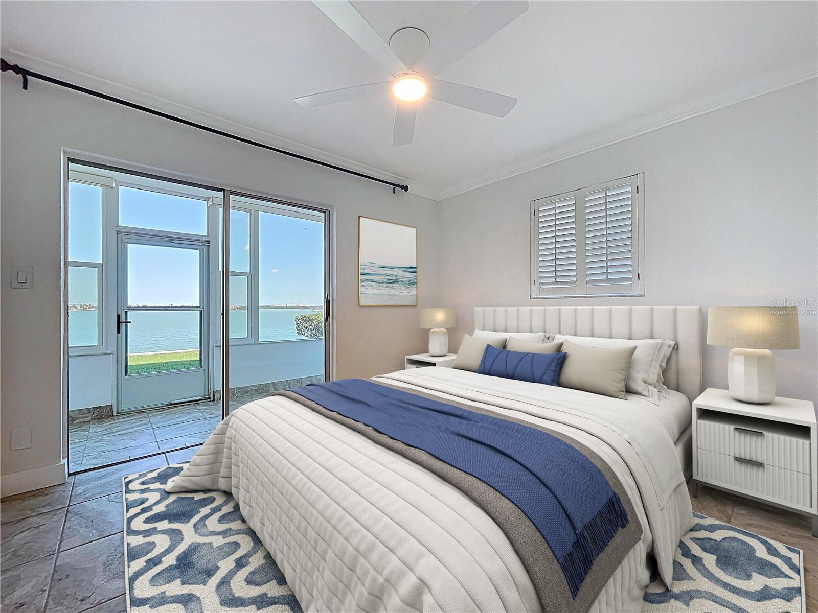 Virtually staged guest bedroom offers water views and direct access to the screened lanai.