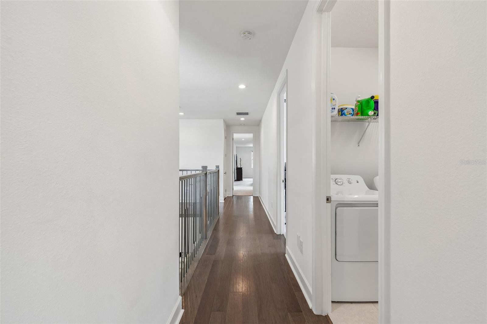 A peek towards the primary suite gives a glimpse of the laundary room.