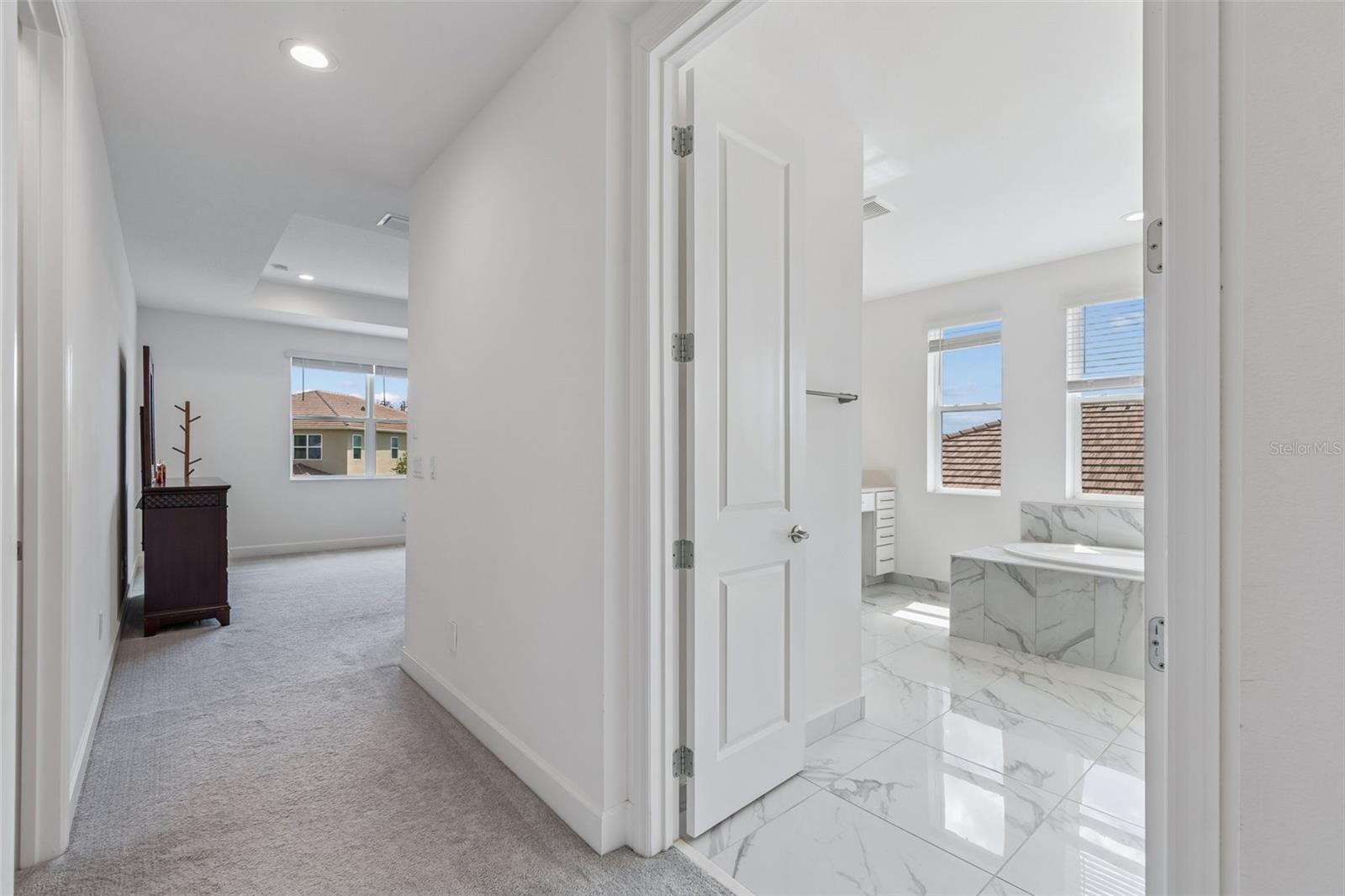 Entering the primary suite, there are 2 large walk-in closets on the left and the bath to the right.