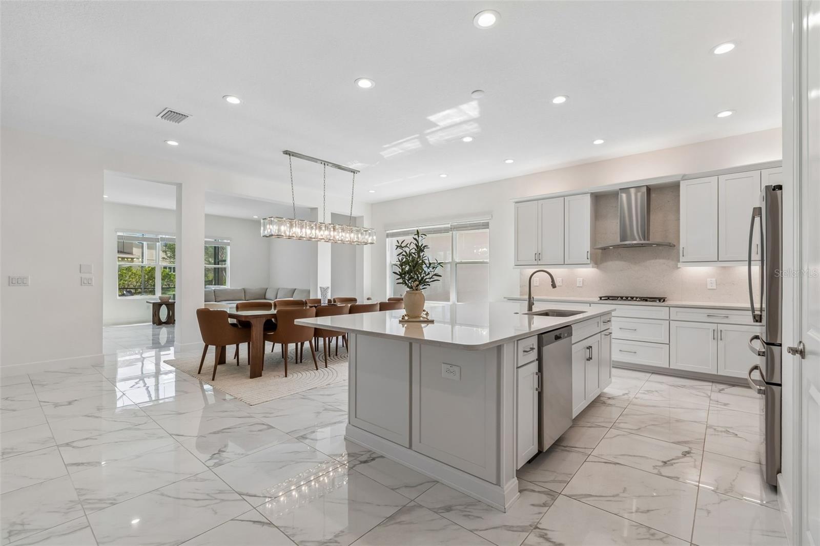 This chef's kitchen features a gas range with exhaust hood vented to the outside.