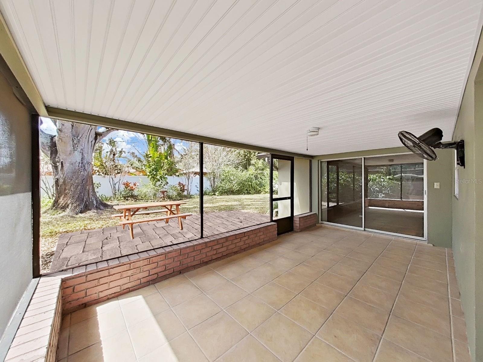 Grand glass sliders lead from the screened Lanai back insode to the Family Room.