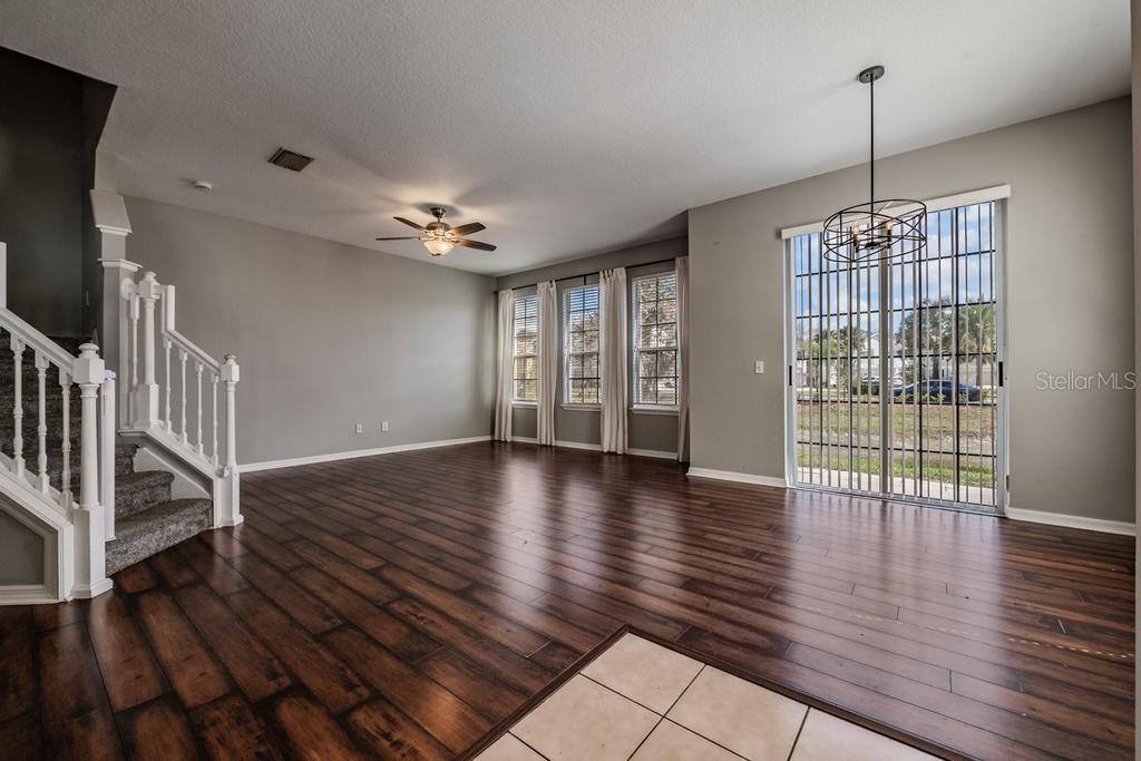 Dining Room/Living Room - lots of natural light and including blinds, drapes, fan and light fixture.