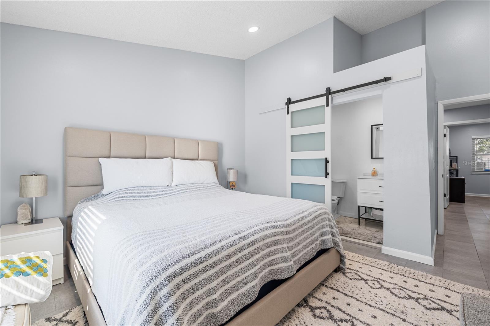 The spacious primary bedroom is modern and light and bright. The high ceilings make it even more cozy.