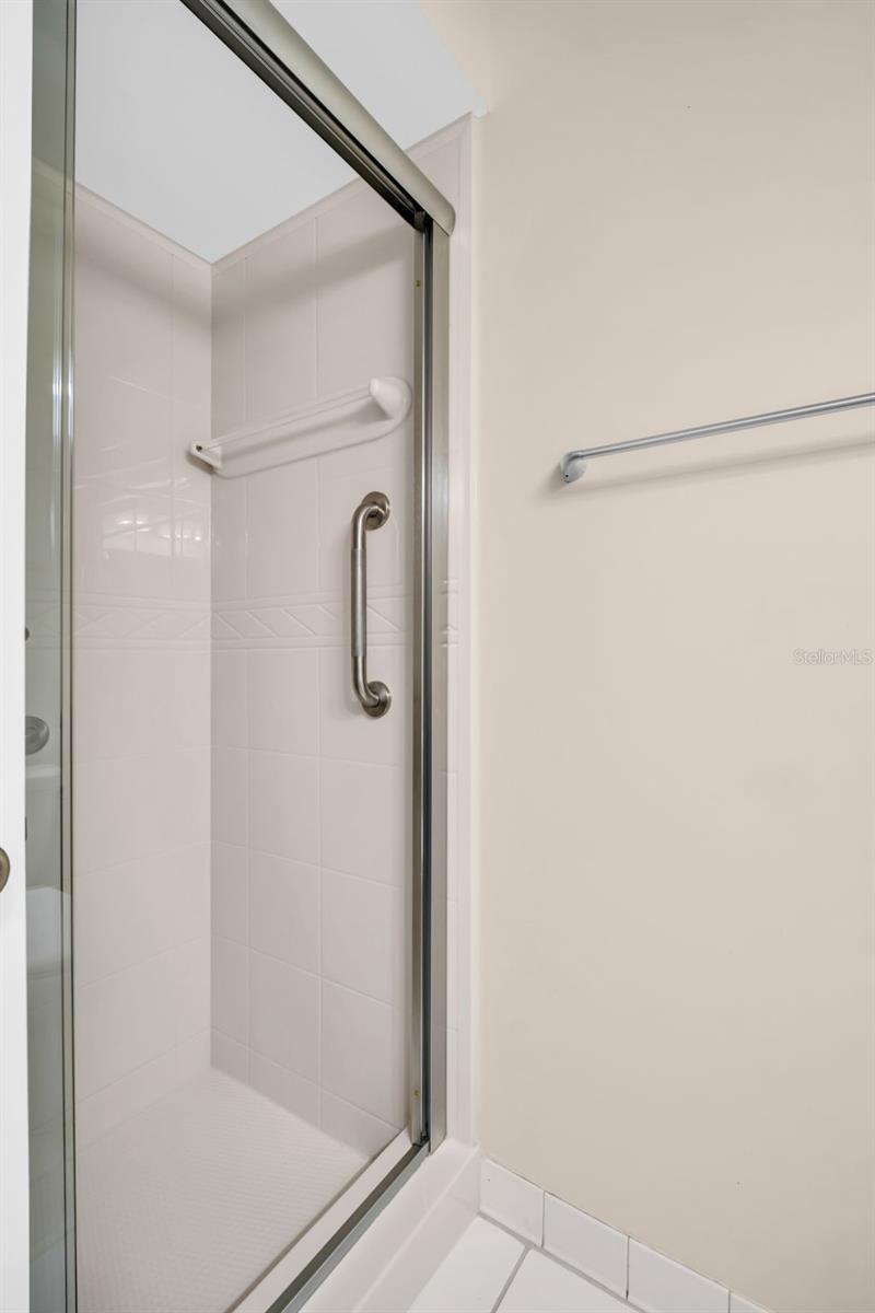 Walk-in shower with grab bar for safety~