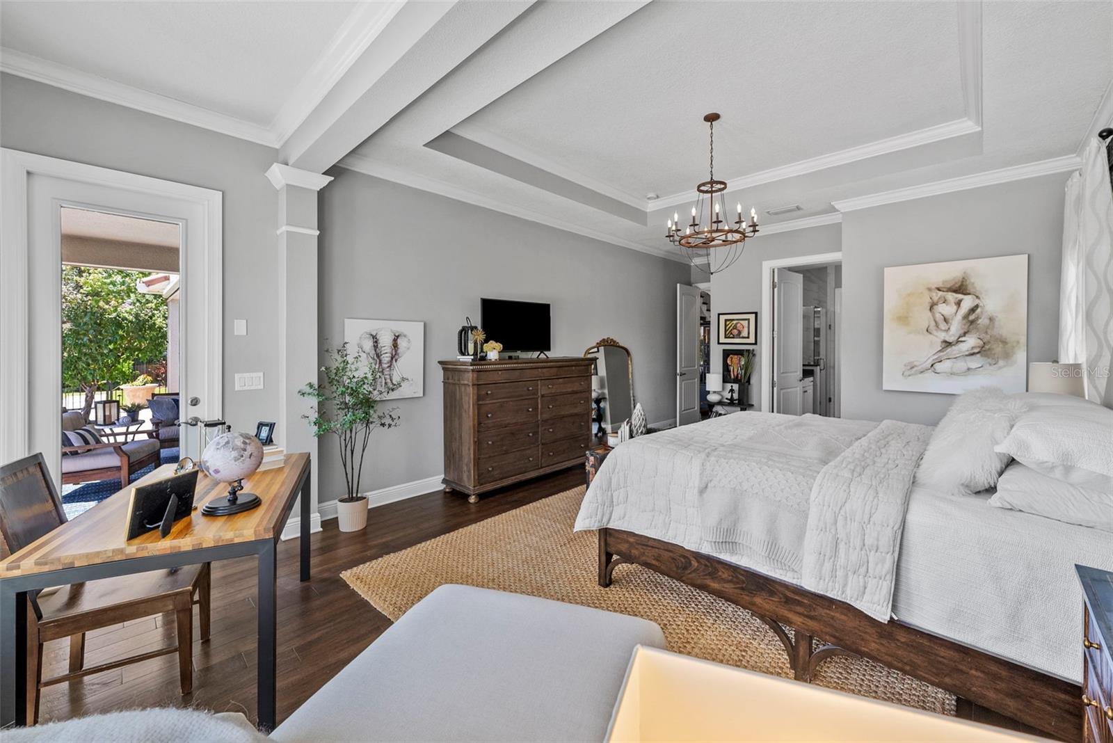 Large suite with coffered ceilings custom lighting, draperies, crown olding, and hard wood flooring