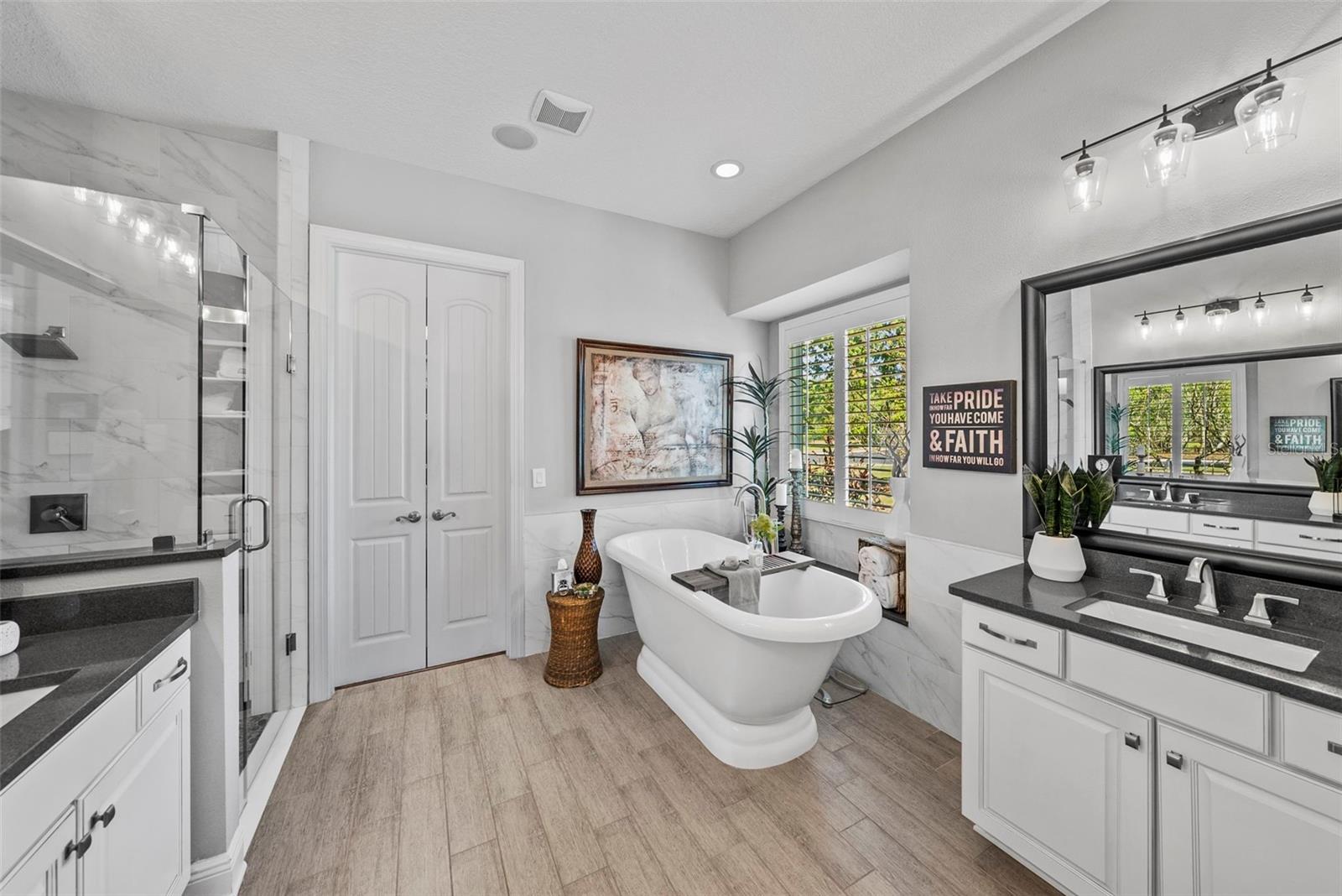 Luxurious Primary Bath with tub, dual vanities, water closet walk in shower and large built-in, walk-in closet