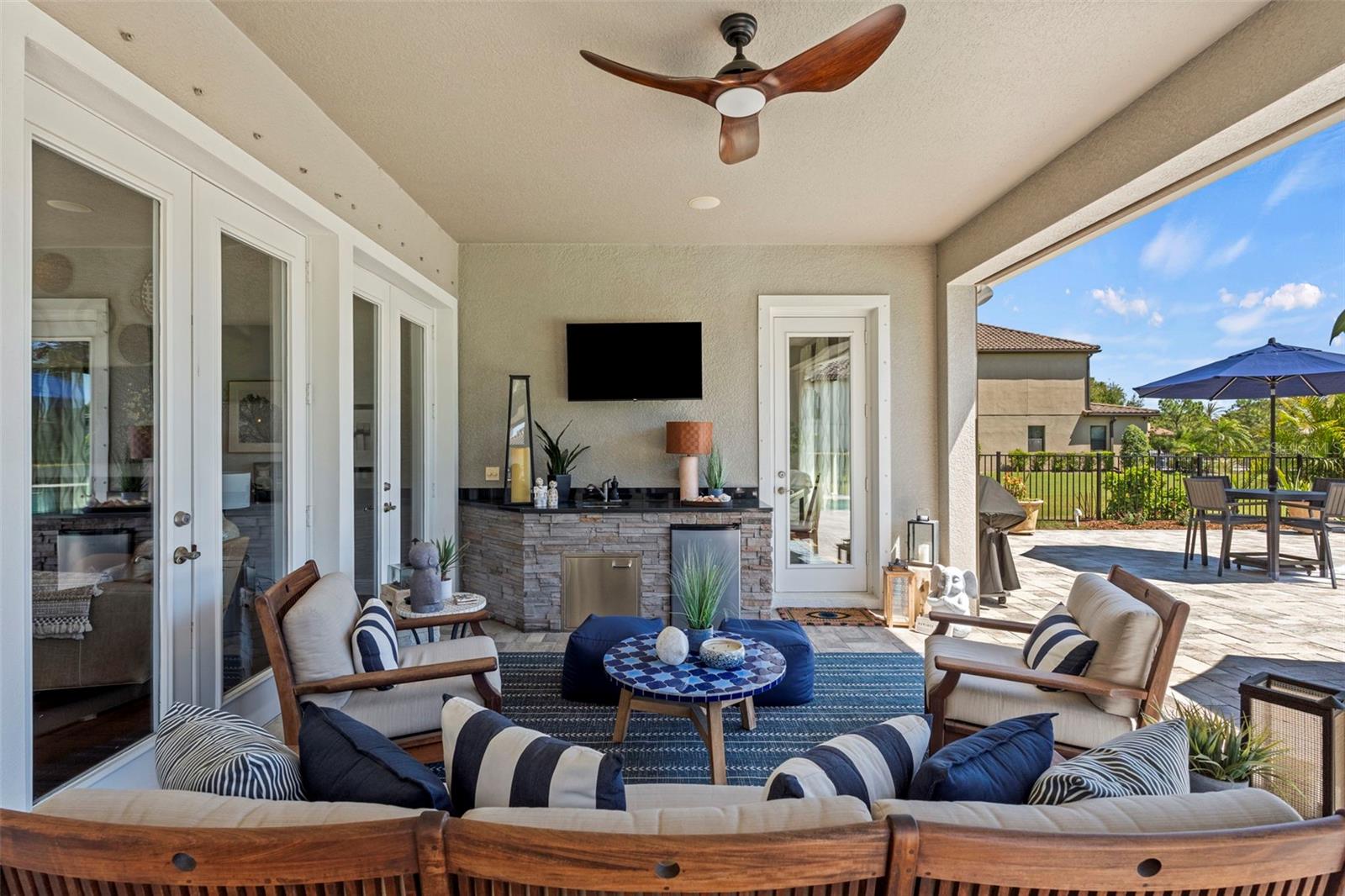 Main covered seating area with TV, refrigerator and sink.