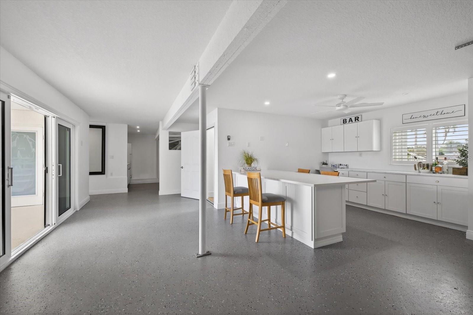 3 car garage opens to pool area and has entertainment area/desk