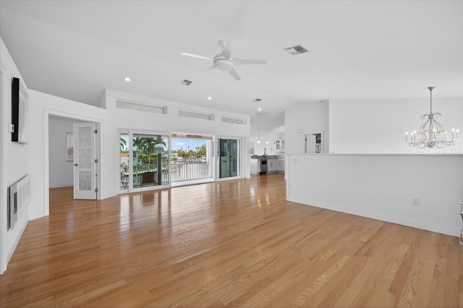 Great Room upstairs looking East toward gourmet kitchen and staircase. Sliders to balcony for water views.