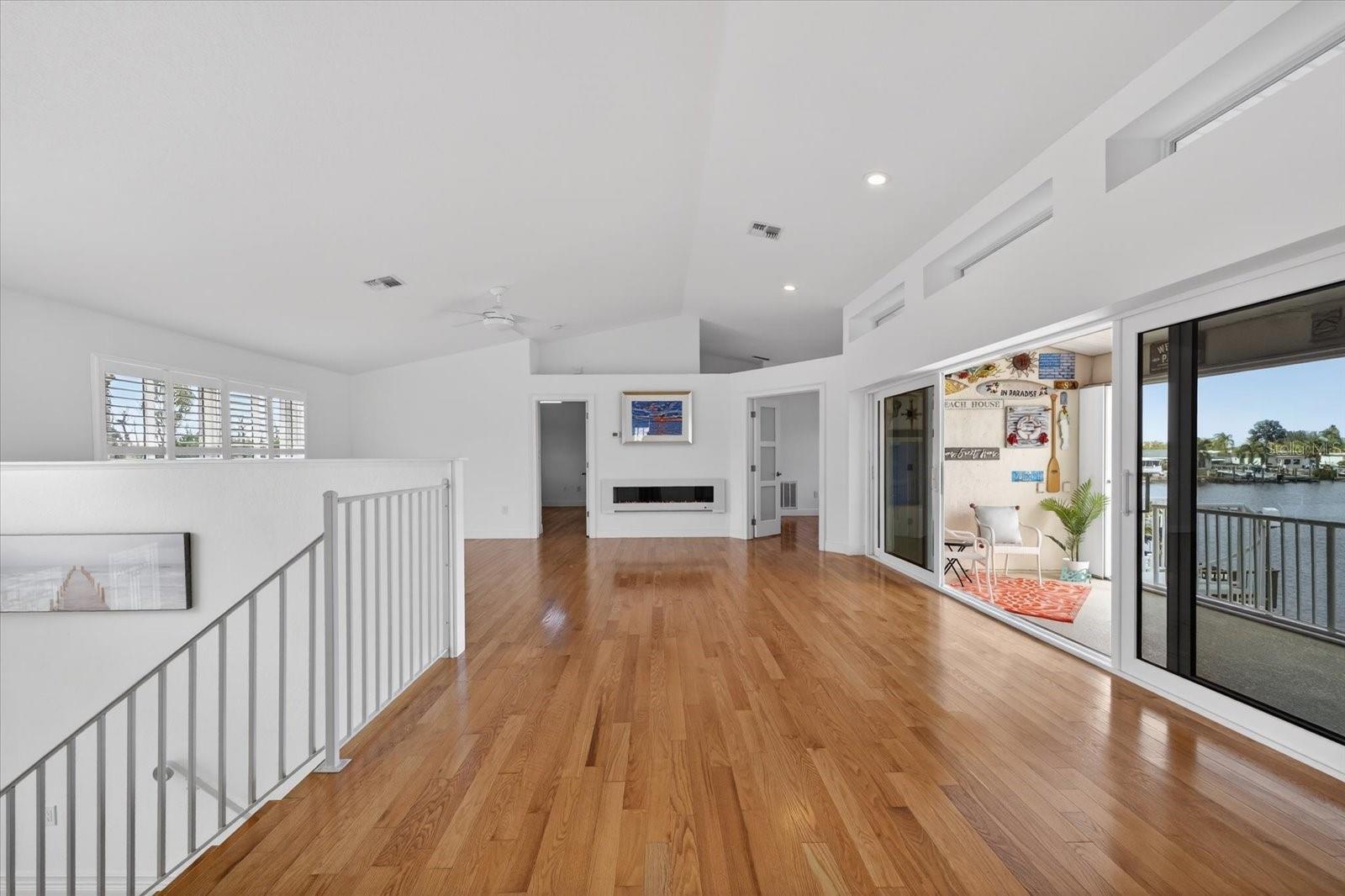 Upstairs Great Room with Electric fireplace and waterfront balcony