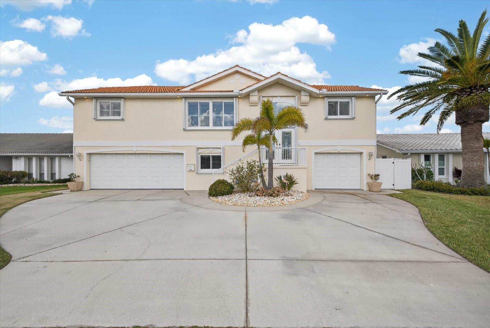 Front view with split 3 car garage and elegant entry.