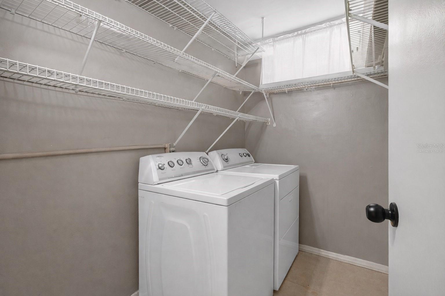 Virtually staged removal of items on shelves. Private personal laundry room and storage.