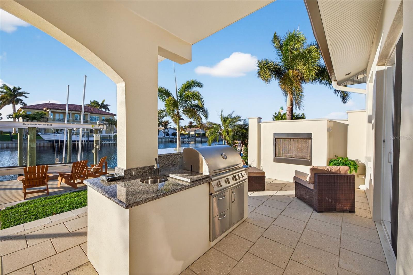 Outdoor living area with gas fireplace, gas grill with lifetime warranty, prep area and sink.