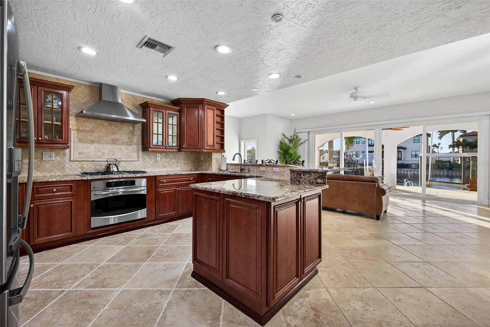 Efficient GE Profile appliances including gas cooktop, convection microwave, electric oven and gas oven, commercial ice maker, and wine fridge. Kohler fixtures and granite countertops.