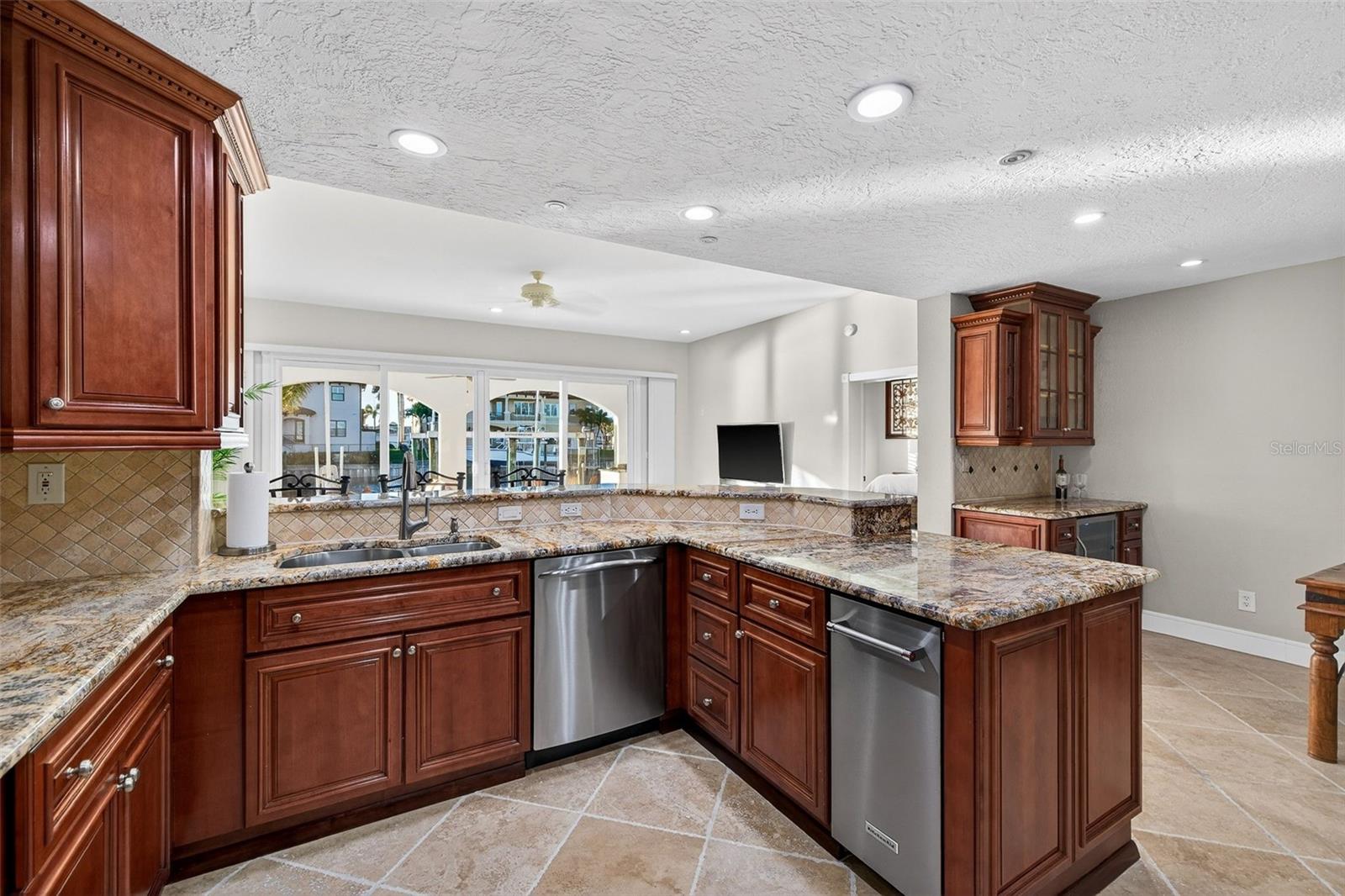 Efficient GE Profile appliances including gas cooktop, convection microwave, electric oven and gas oven, commercial ice maker, and wine fridge. Kohler fixtures and granite countertops.