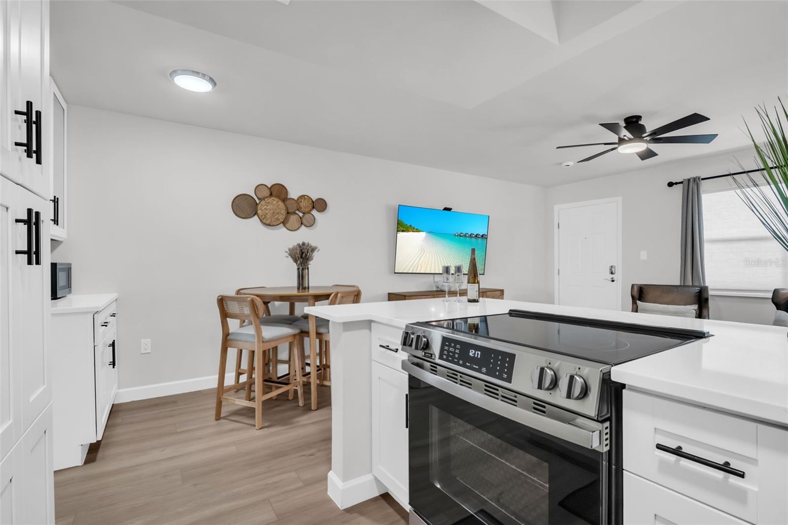 Highlight the ease of having a TV and dining area right where the food is prepared.