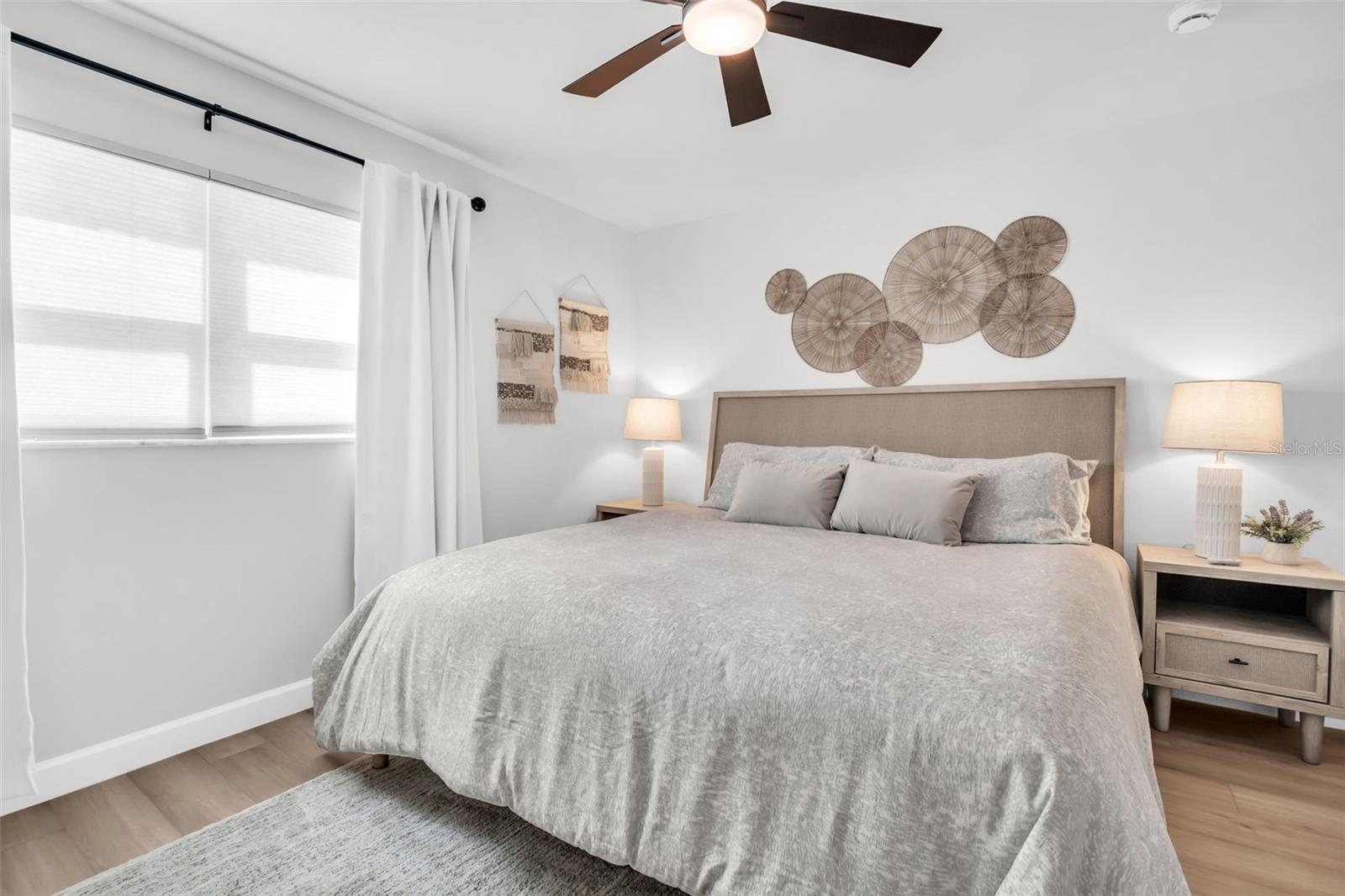 Retreat to this serene primary bedroom, featuring layered, plush bedding and a soft, neutral color palette designed for ultimate relaxation.
