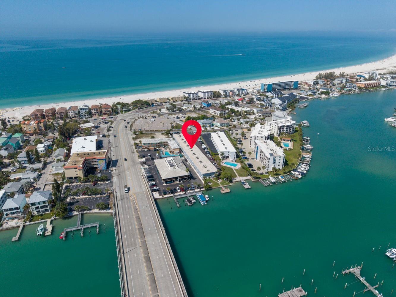 This aerial captures the pristine, sandy beach and its location, highlighting the serene waterfront lifestyle.