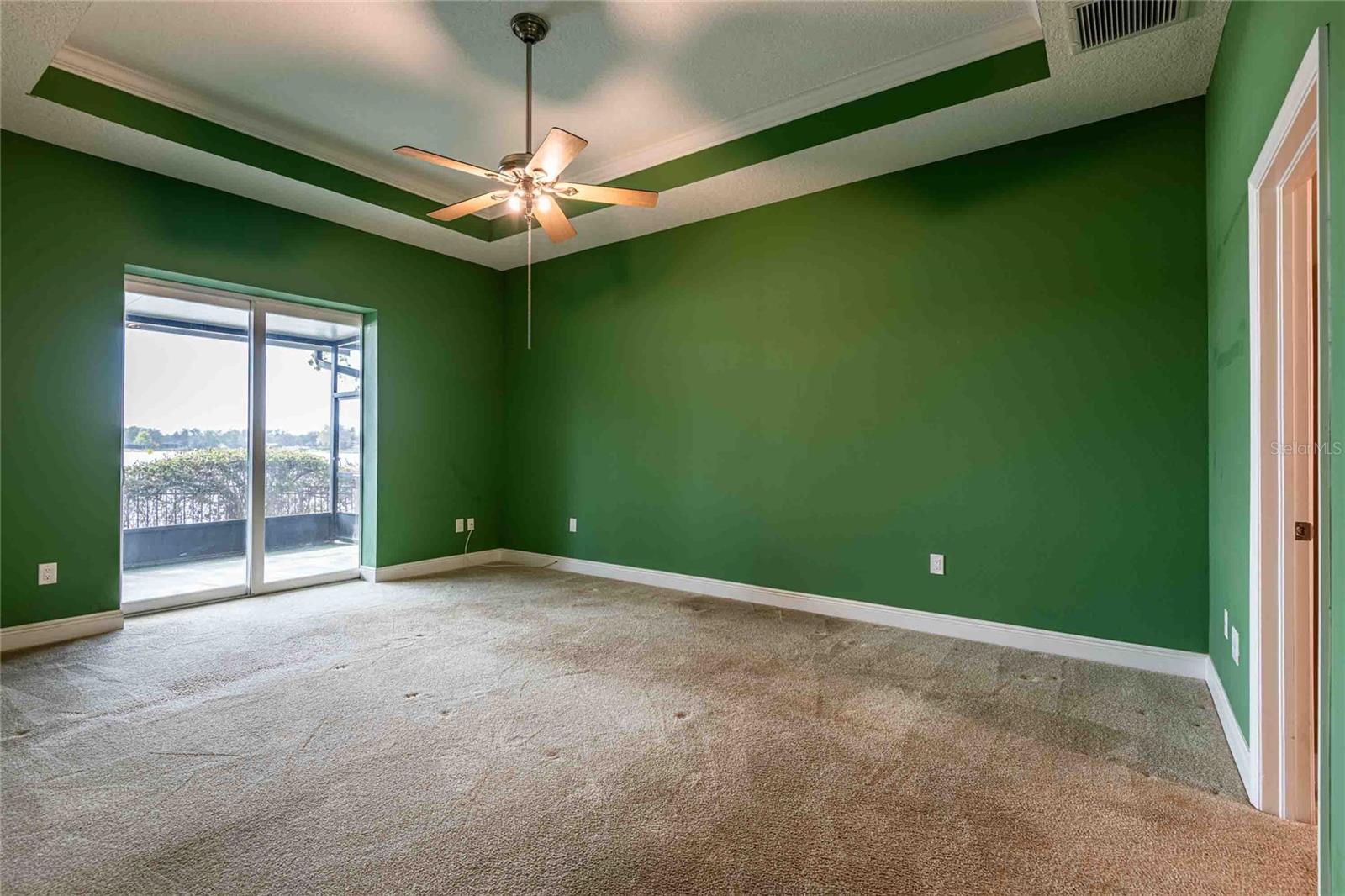 Master bedroom with sliding glass doors to lanai and hot tub and lake