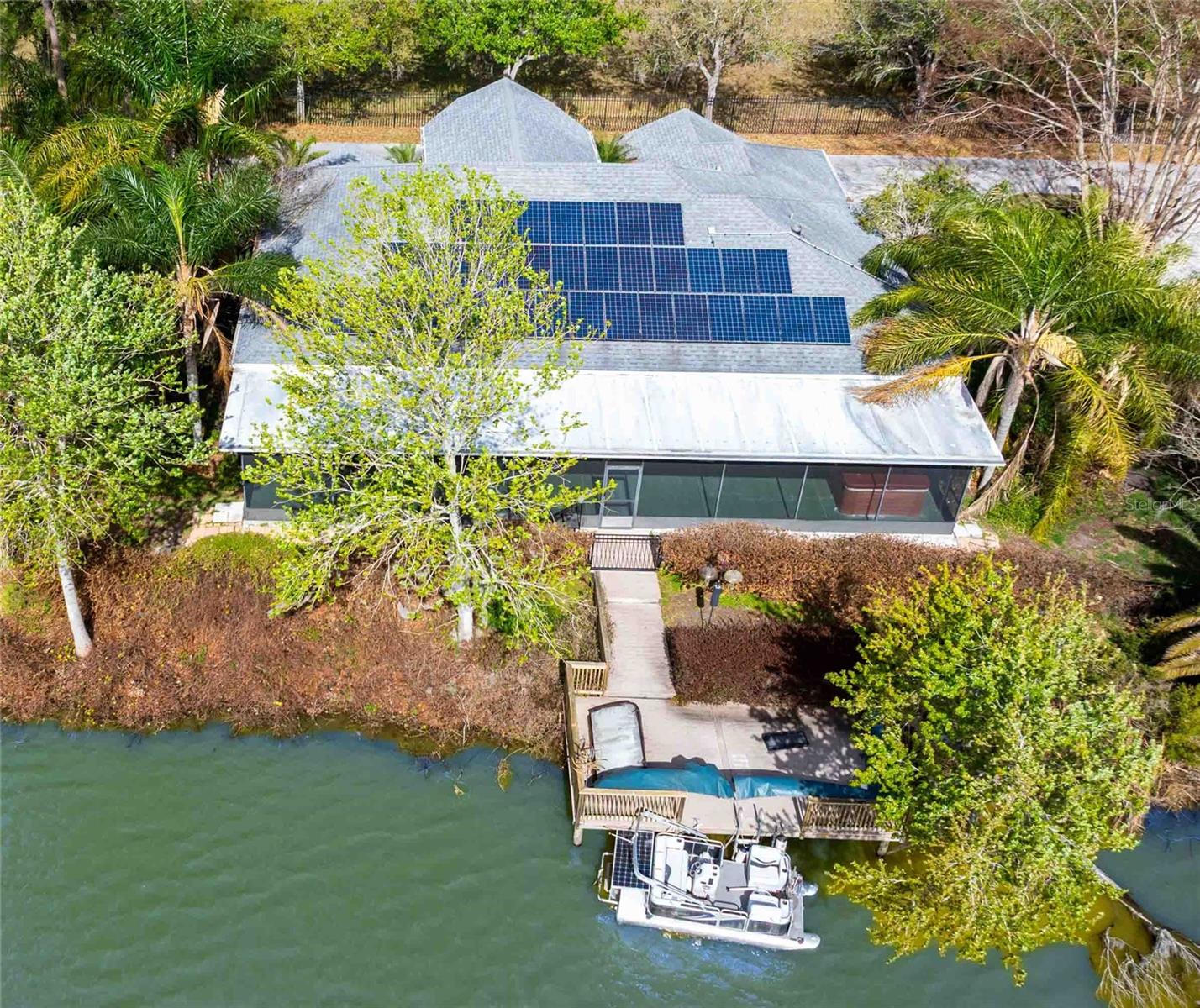 Aerial view of the solar panels, large screen lanai with hot tub and dock