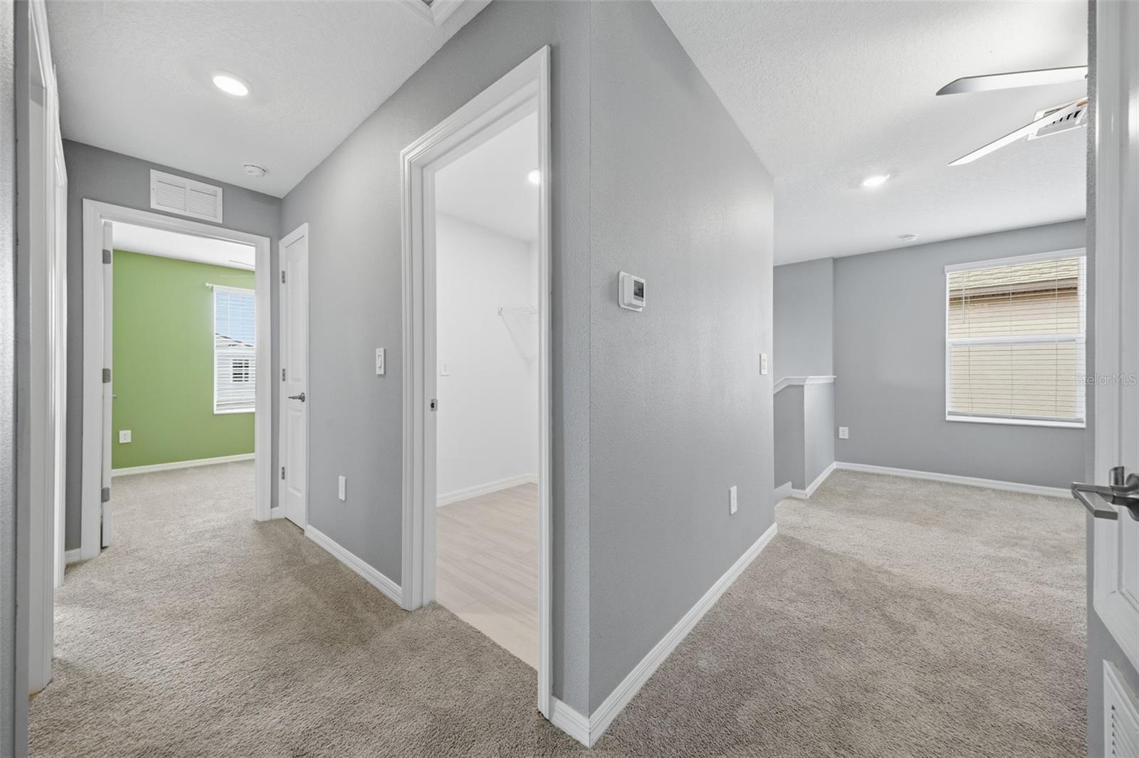 View of the loft, laundry room and hallway to secondary bedrooms