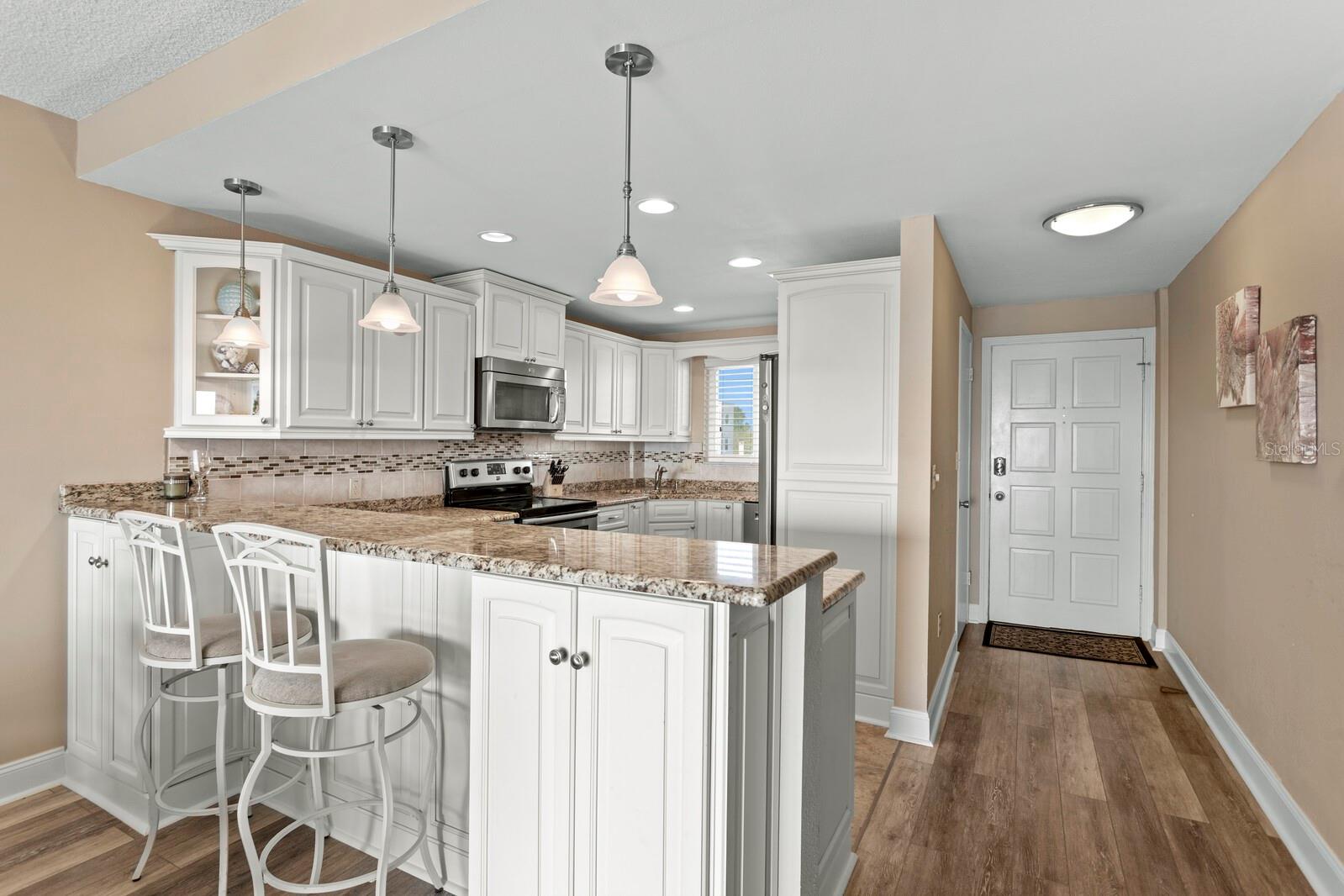 Kitchen wall taken out; replaced with marble counter top; breakfast bar.