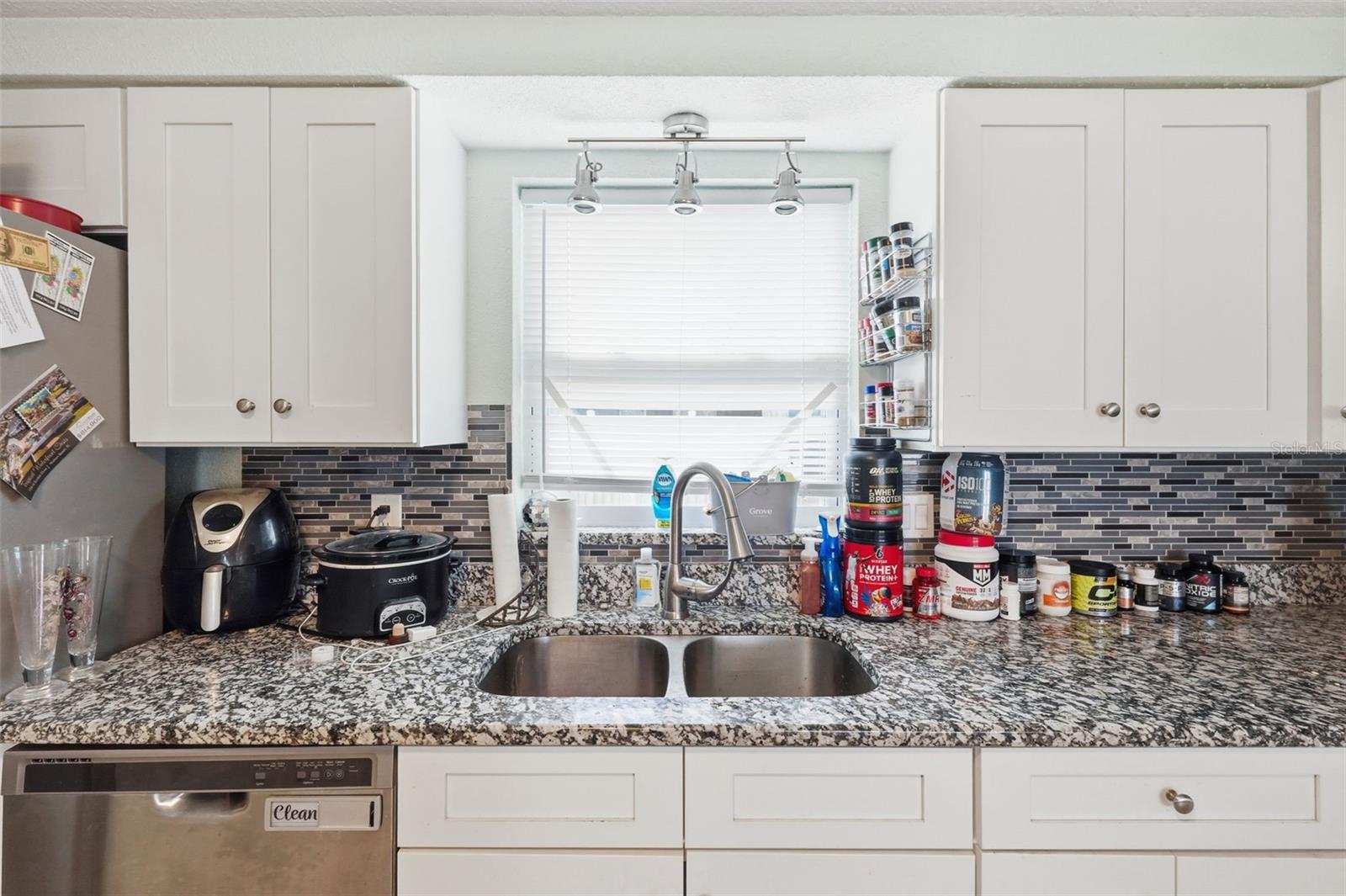 Kitchen view facing sink and backyard through window