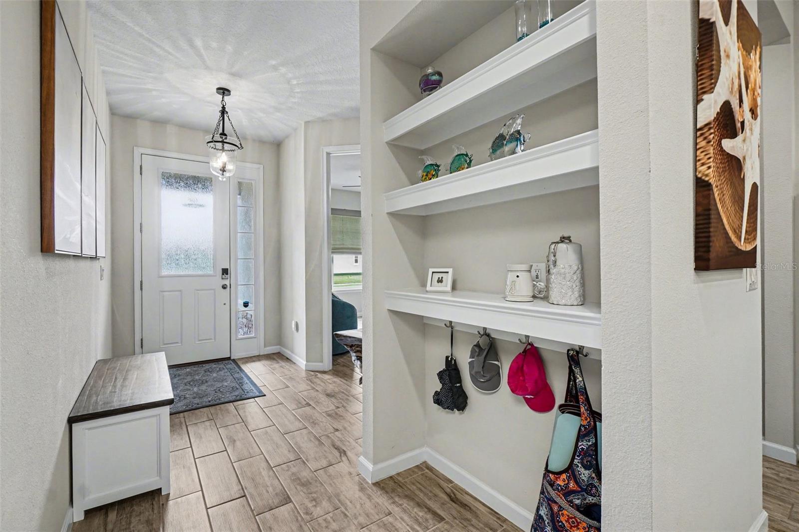 Foyer is bright and welcoming - with decorative built-in shelves and hooks.