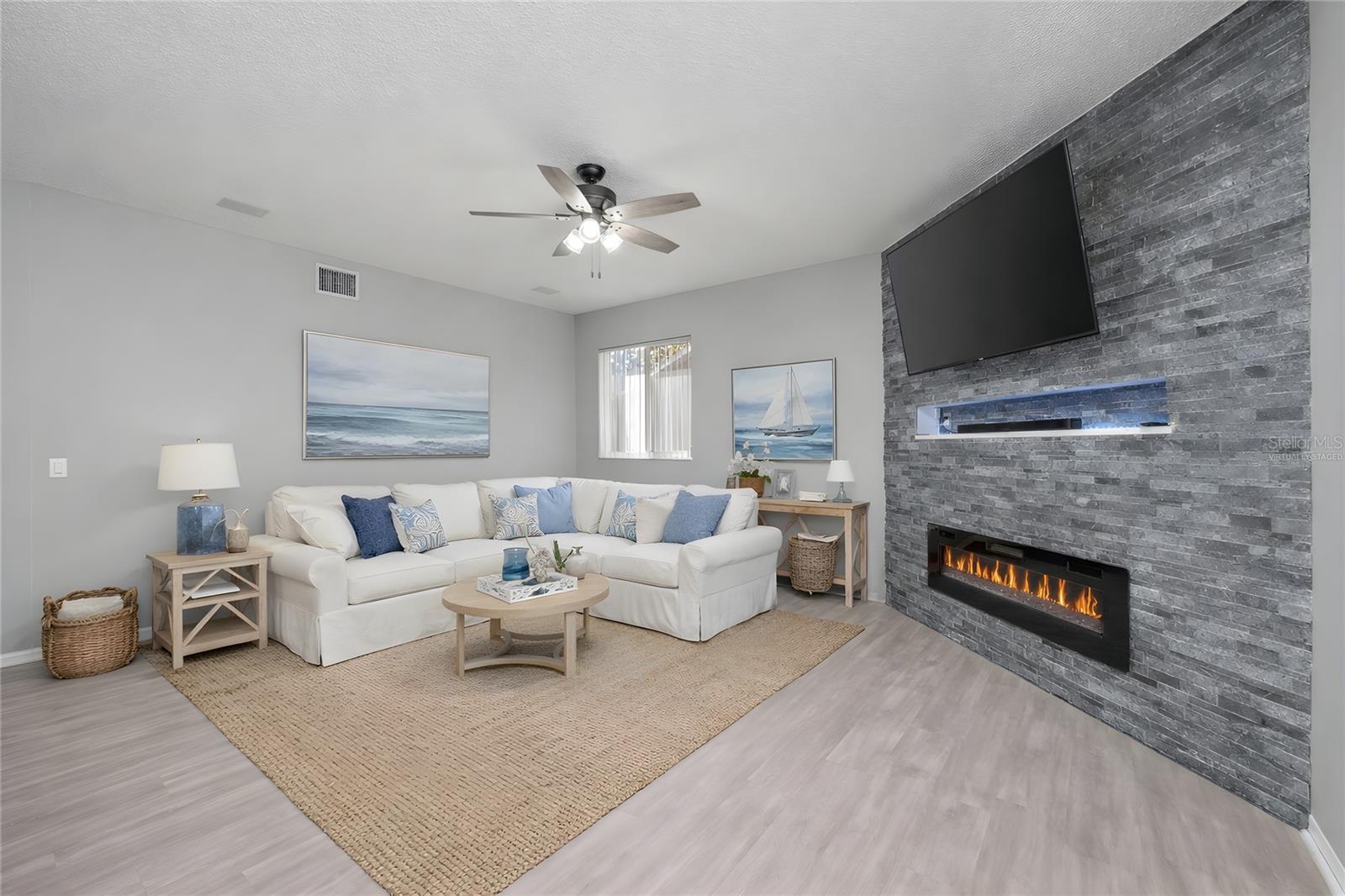 Virtually Staged - Family room with custom stone wall and electric fireplace