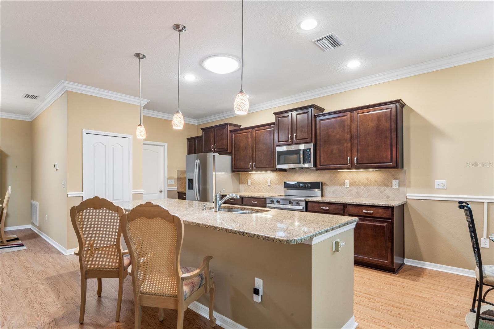 KITCHEN VIEW SHOWING AMPLE CABINETS, BREAKFAST BAR AND PANTRY