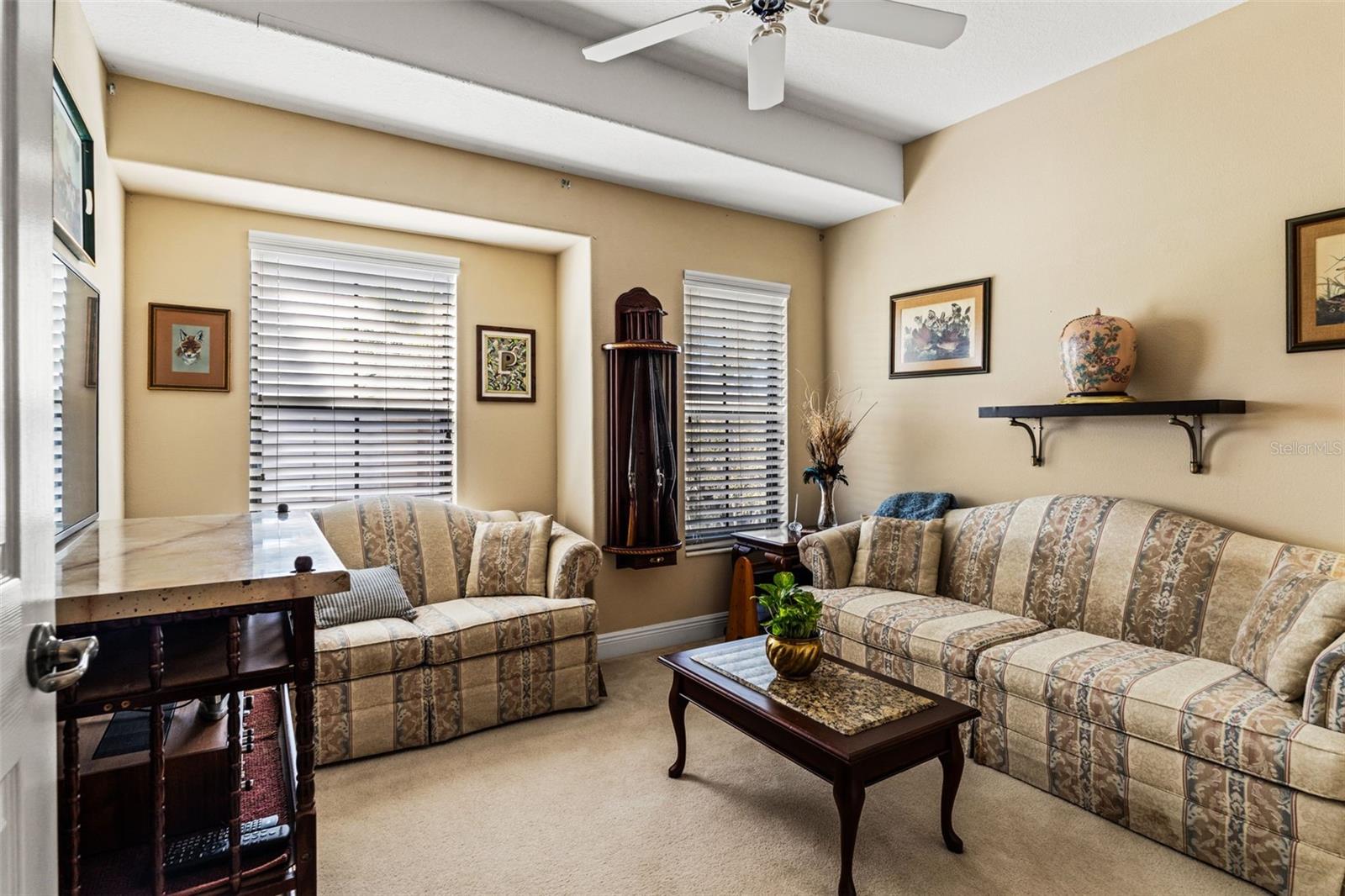 Cozy bedroom featuring neutral tones, ceiling fan, and abundant natural light.