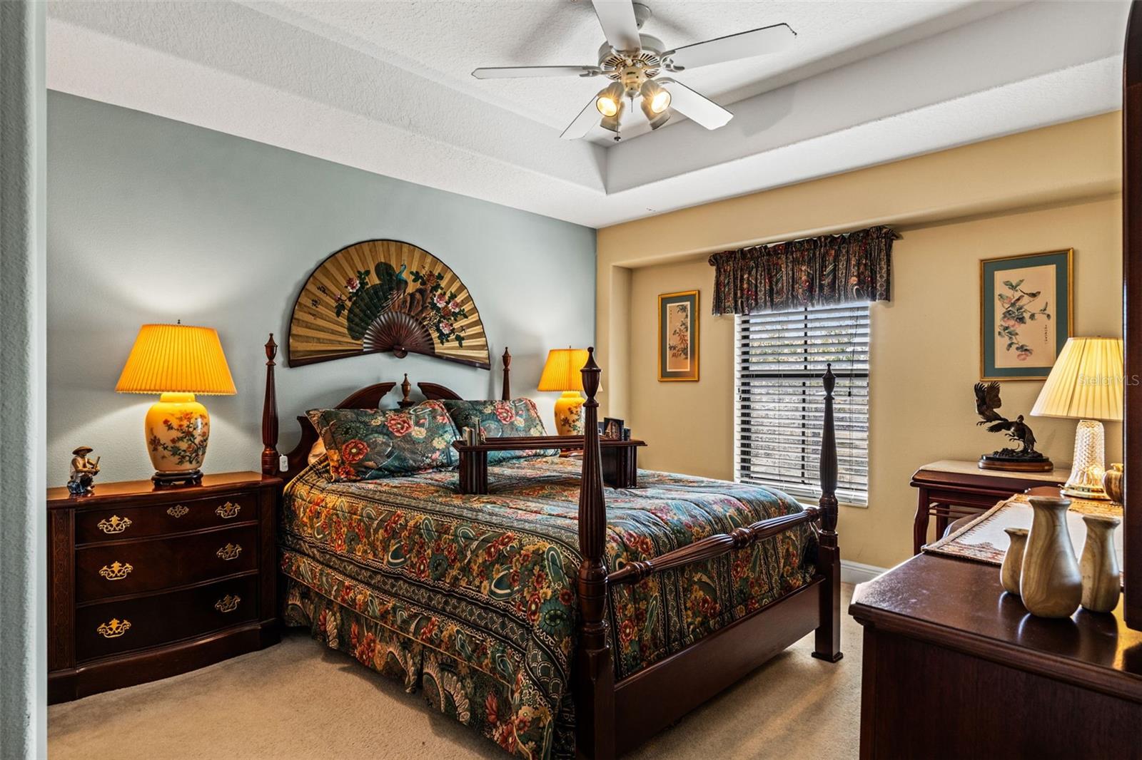 Well-appointed bedroom with classic furnishings, tray ceiling, and generous space for additional seating or décor.