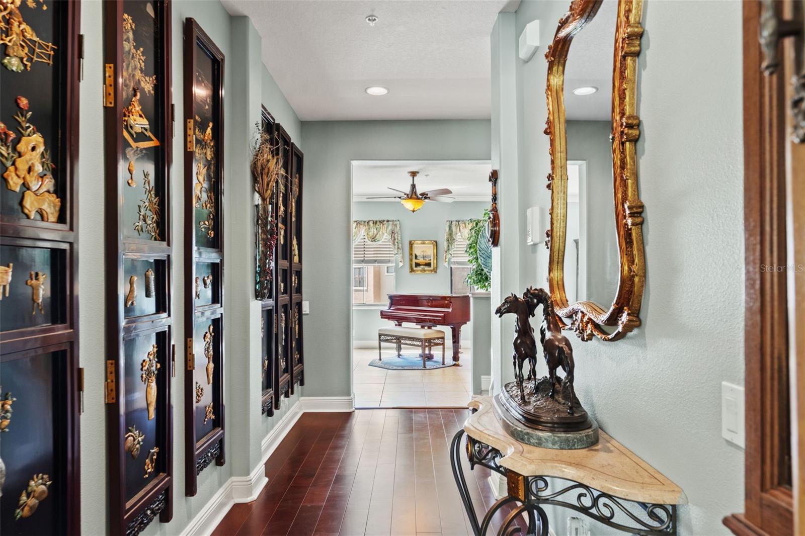 Welcoming entry corridor with wood flooring, decorative wall accents, and soft natural light guiding you into the main living spaces.