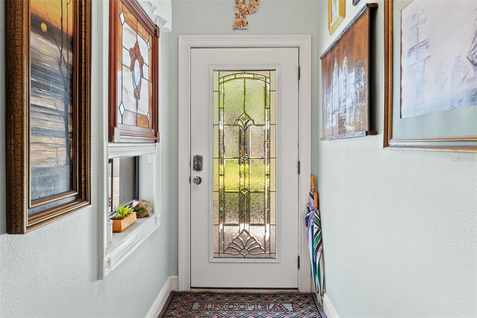 Inviting front entry with decorative glass door panel allowing natural light to brighten the foyer.