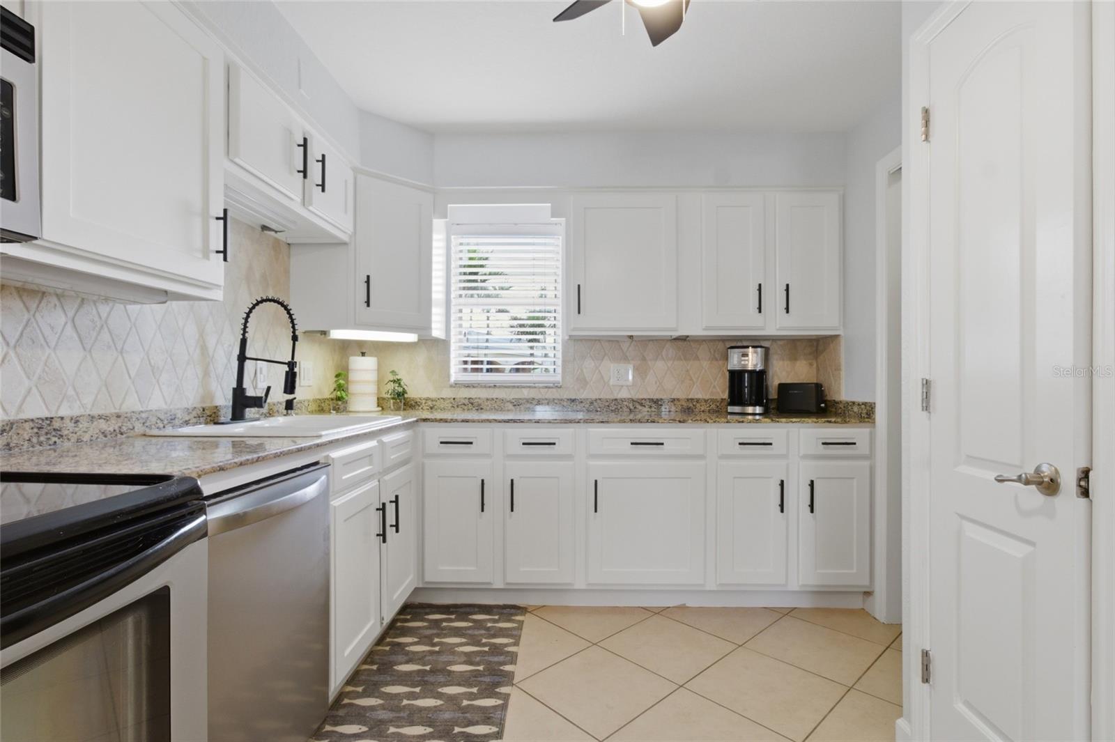 Updated Kitchen with granit counteres and solid wood cabinetry, crown molding