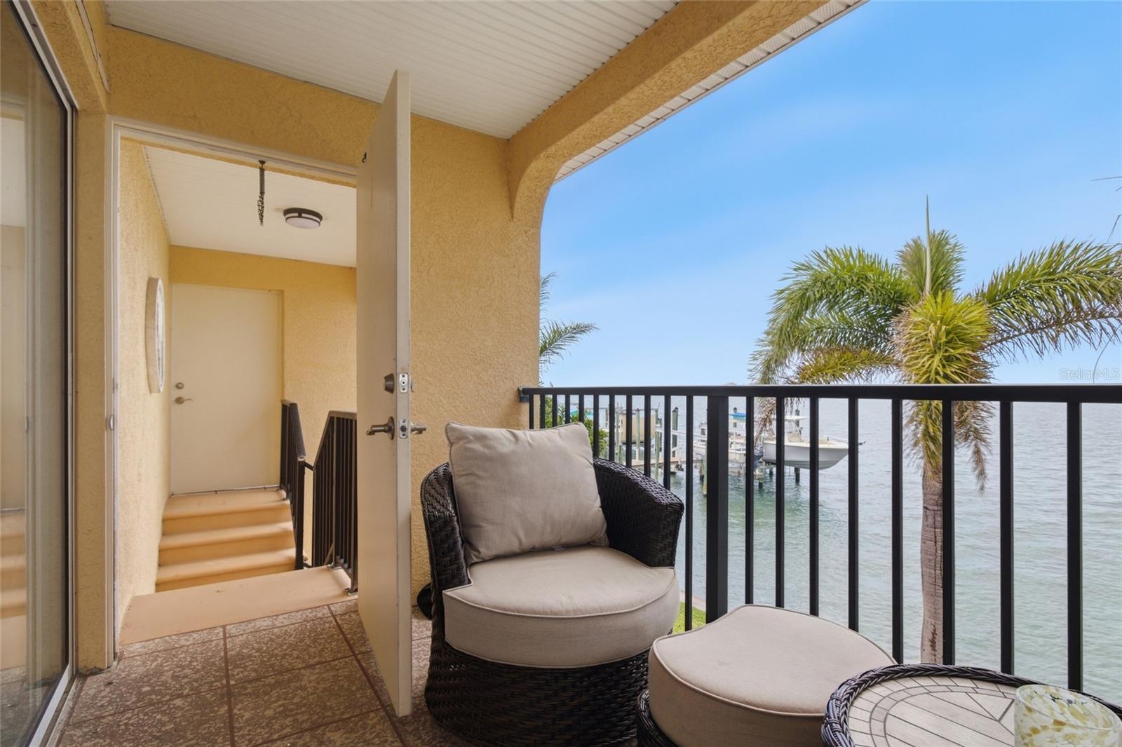 Spacious Balcony/Patio with back door and staircase to Backyard and water
