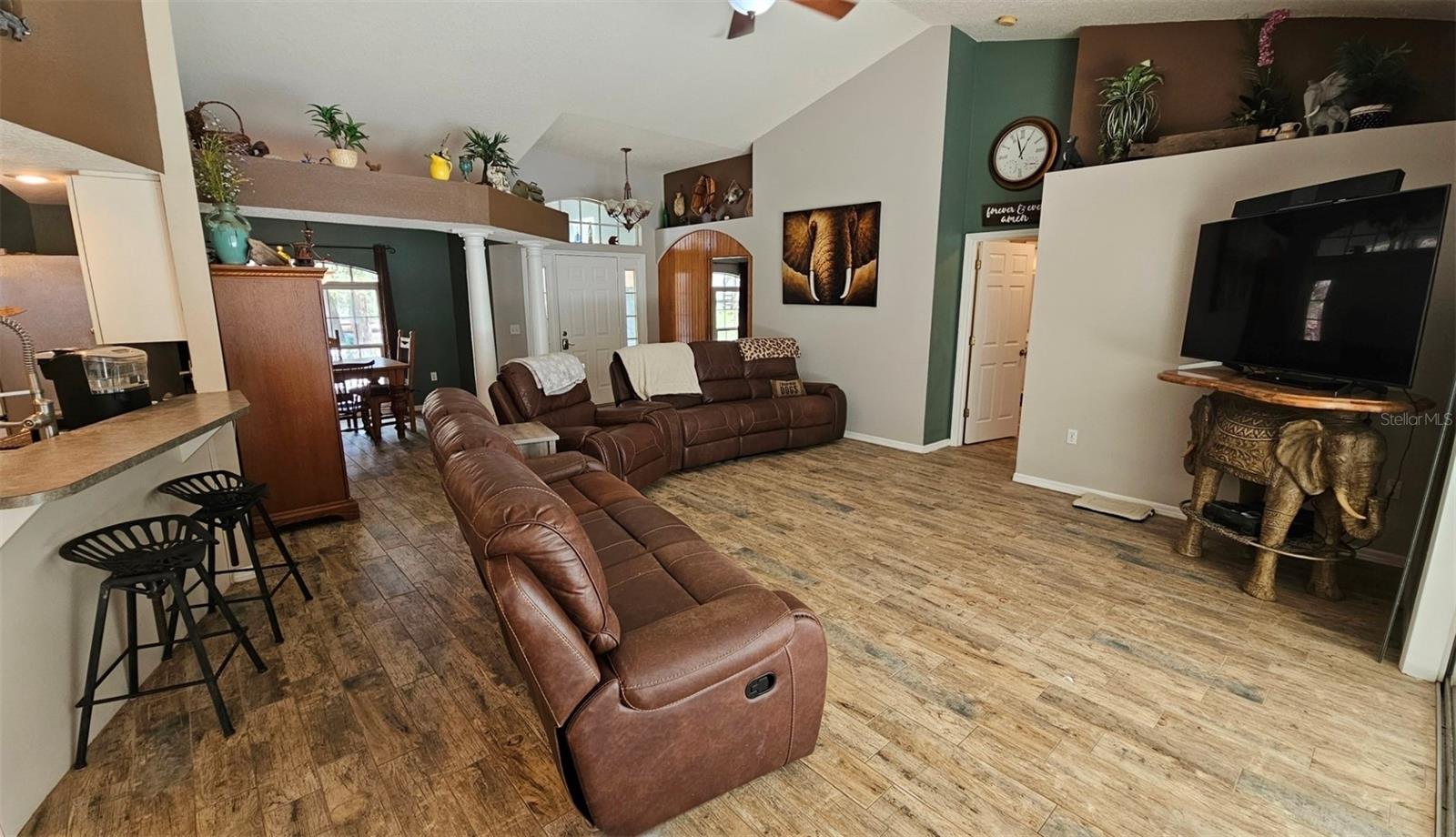 Spacious Open Floor plan showing kitchen high top breakfast bar  & living room with vaulted ceilings