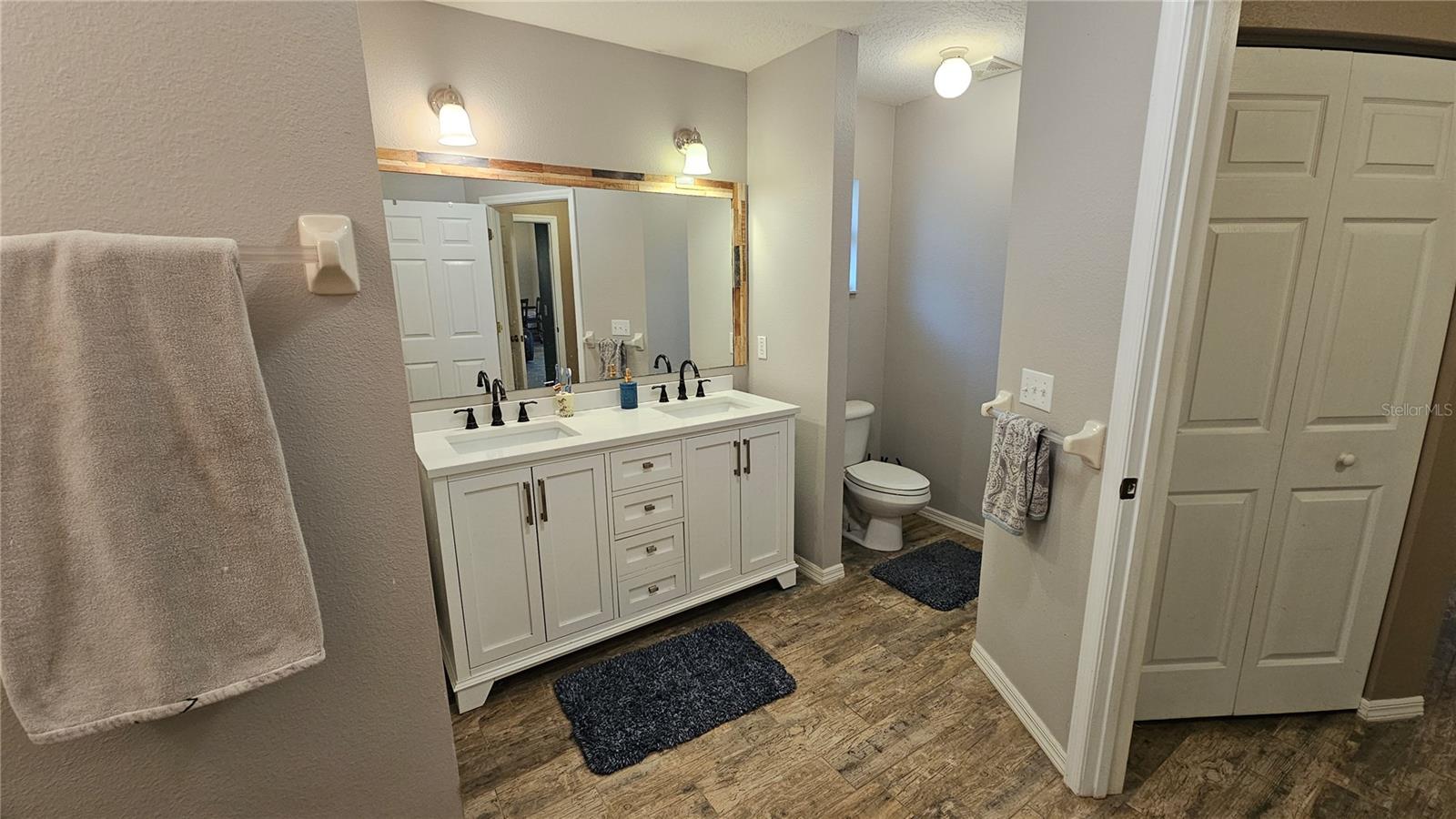 Master Bathroom with newly updated shower & dual sink vanities, makeup vanity & linen closet