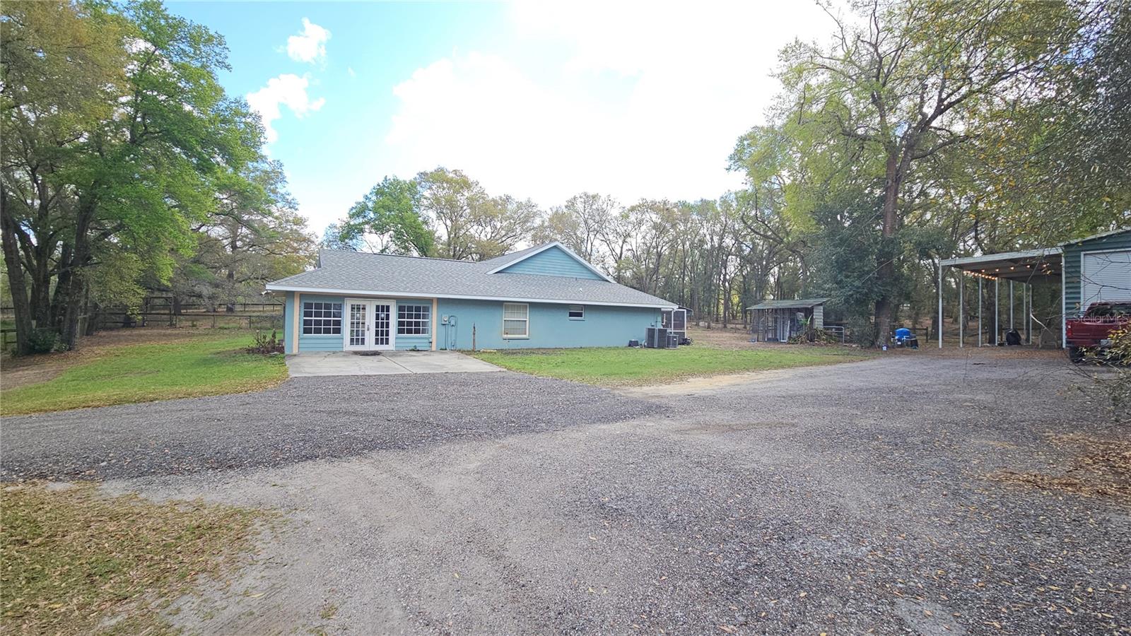 View of Right sign of home & long driveway to metal building/shop