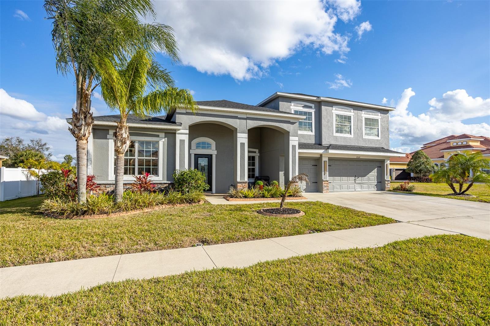 Front view of a 2-story gray luxury home with 3-car garage.