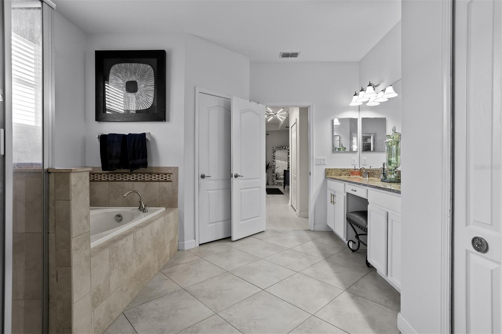 Spa-like master retreat featuring a deep garden soaker tub and separate glass shower.